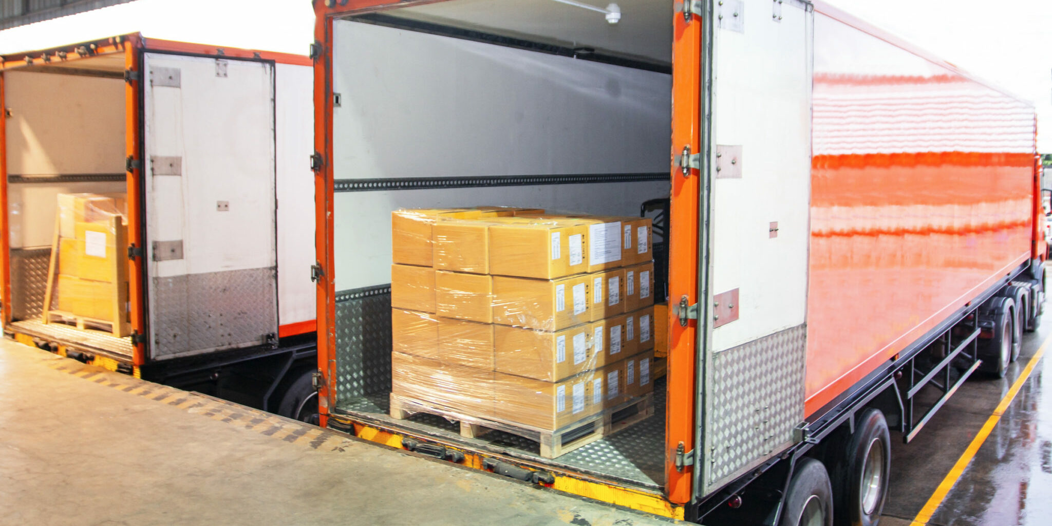 Package Boxes Load with Cargo Container. Trailer Truck Parked Loading at Dock Warehouse. Delivery Service. Shipping Warehouse Logistics. Cargo Shipment Boxes. Freight Truck Transportation.